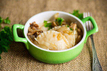 Potato dumplings with onion and mushrooms in a plate.