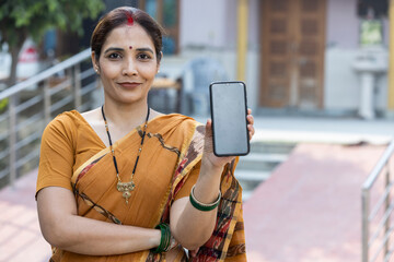 Indian rural woman showing smartphone screen.