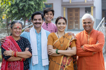 Portrait of happy multi-generation family standing at outside the home.