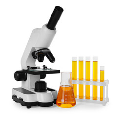 Laboratory glassware with orange liquid and microscope isolated on white