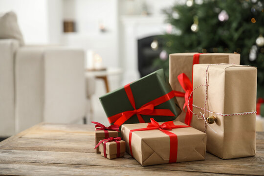 Beautifully wrapped Christmas gifts on wooden table indoors, space for text