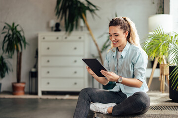 Happy blonde girl, using a digital tablet, working over it.