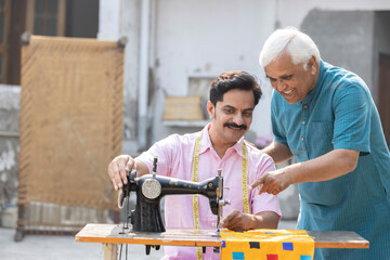 Senior teacher helping a man learning to use the sewing machine.