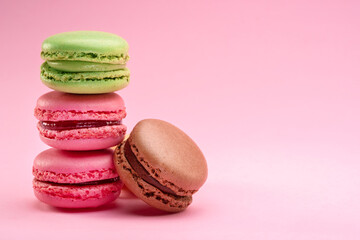 Fototapeta na wymiar Colorful french macarons isolated on pink background.