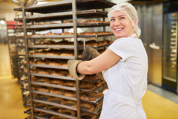 Bäcker Lehrling schiebt fertig gebackene Croissants