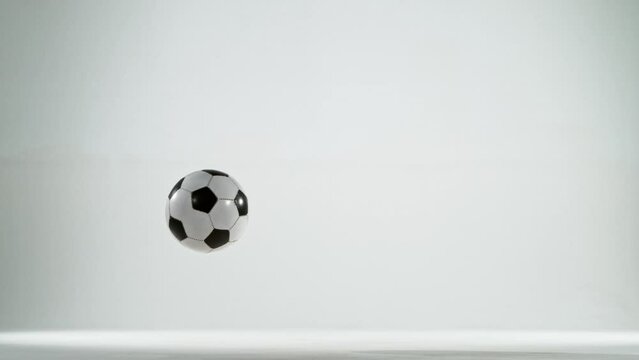 Super slow motion of jumping soccer ball on white background. Filmed on high speed cinema camera, 1000fps.