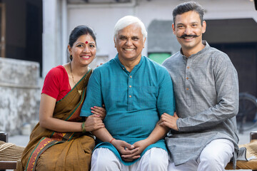 Happy Indian Couple Spending Time With Father At Home