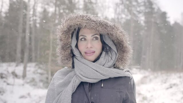 Smiling woman face in snowfall during mid day in winter