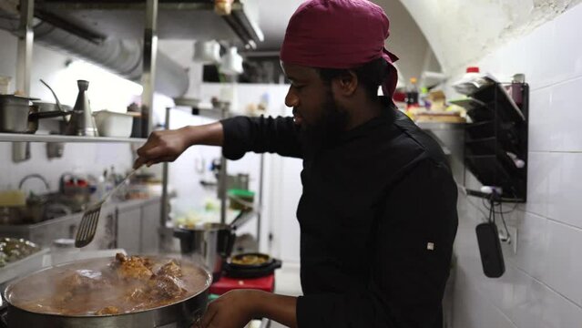 african american chef preparing a stew in restaurant kitchen