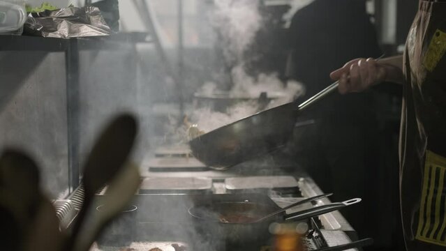 Chef Cooking Food in Pan wth Steam Smoke Professiona Kitchen Restaurant