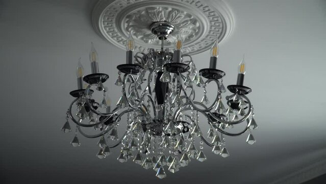 The chandelier swings from buildings shaking during an earthquake. Wide shot