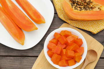 Tasty cut papaya fruits on wooden table, flat lay