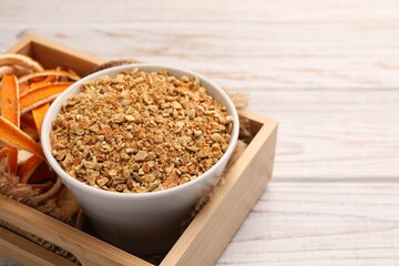 Dried orange seasoning zest and peel on white wooden table, space for text