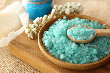 Fototapeta na wymiar Turquoise sea salt and beautiful flowers on table, closeup