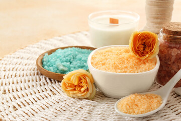 Aromatic sea salt and beautiful flowers on wicker mat. Space for text