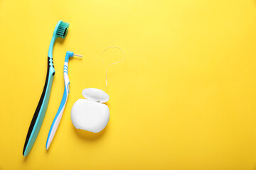 Flat lay composition with dental floss and different teeth care products on yellow background....