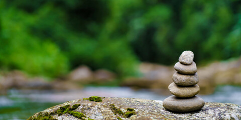 Photos of stacked stones with green background give a fresh and relaxed feeling, Balance and harmony in nature