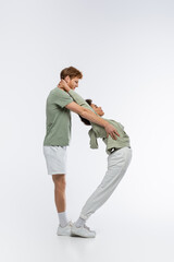 Fototapeta premium side view of interracial couple showing d letter with bodies on white background.