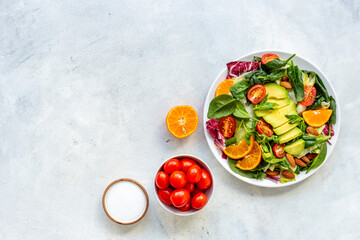 Healthy vegetarian lanch with bowl of green salad with avocado and tomatoes