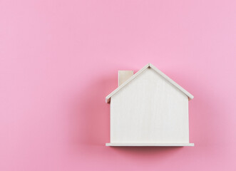 Obraz na płótnie Canvas flat lay of wooden model house on pink background.