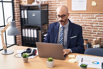 Young hispanic man business worker using laptop working at office