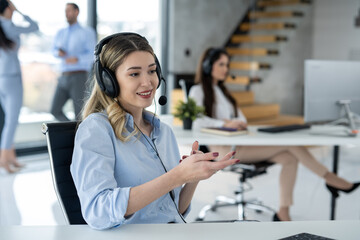 Beautiful business woman in headset working at customer service office.