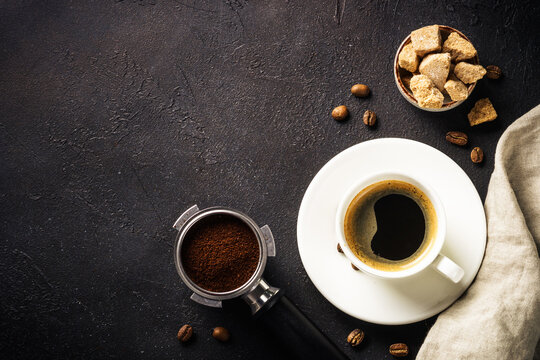 Coffee cup and coffee beans at dark table . Top view image with copy space.