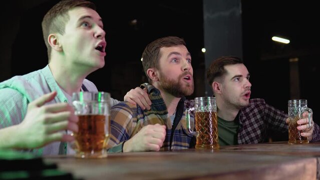 Loyal football fans supporting their team. Men cheering their team in the pub