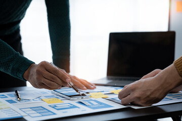 ux developers and ui designers, data researchers brainstorm on  tabletop mobile app interface wireframe design with client summary color codes the modern office Creative Digital Development Agency.