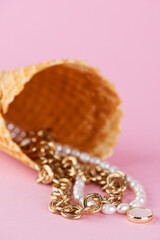 Necklace or choker made of pearls with a mother-of-pearl pendant and golden chain in waffle cone on...