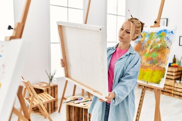 Young caucasian woman artist looking draw at art studio