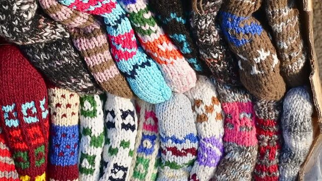 Close up traditional beautiful colorful hand-made socks for sale on display outside on babushkas stall