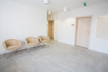 An elegant waiting room in a modern medical facility. Clinic with white walls and comfortable...