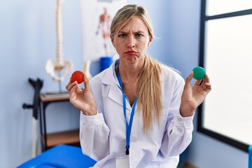 Beautiful woman holding strength ball for hand rehabilitation skeptic and nervous, frowning upset because of problem. negative person.