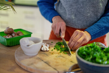 Woman chopping parsley at home