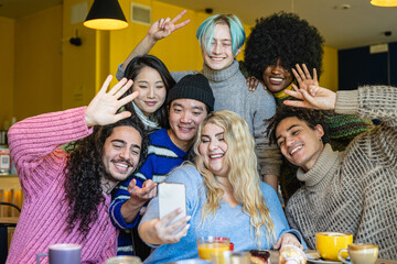 Young curvy woman takes a photo with her best friends during a breakfast in cafe, multiracial and inclusive diversity group, focus on asiatic boy face