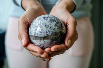 Close-up of female hands holding crystal ball