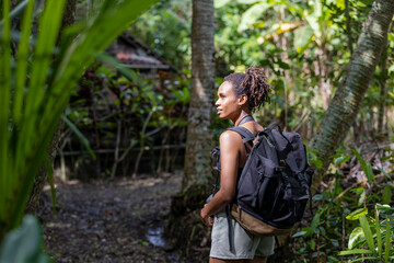 Naklejka na ściany i meble Indonesia, Bali, Female tourist hiking in rainforest