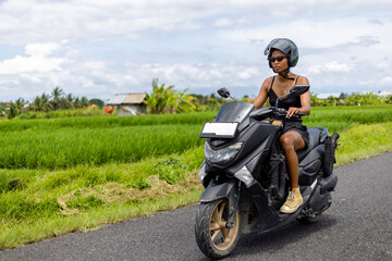 Fototapeta na wymiar Indonesia, Bali, Female tourist on motorcycle road trip