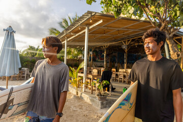 Fototapeta Surfers standing with surfboards on beach obraz