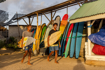 Fototapeta Surfers walking with surfboards on beach obraz