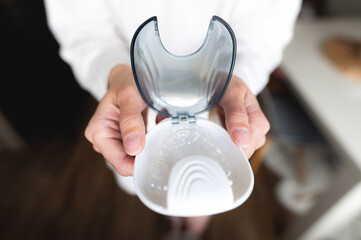 Close-up of a plastic transparent brace in a box in the hand of a young woman. selective focus