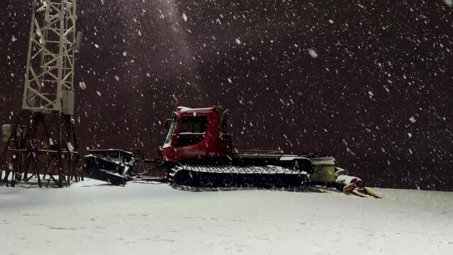 Ratrack snow groomer. snowcat. Night. Very heavy snowfall. side view.