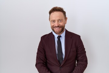 Middle age business man with beard wearing suit and tie with hands together and crossed fingers smiling relaxed and cheerful. success and optimistic