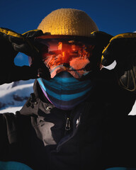 Close-up of men's ski goggles with reflection of snowy mountains. man against the blue sky. Winter...