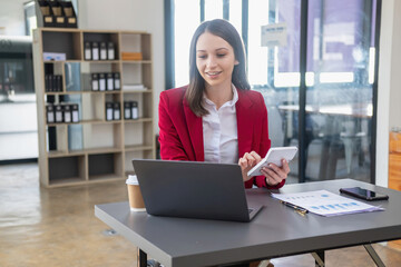 Fototapeta premium Marketing, Financial, Accounting, Planning, business women analyze company results and profits with graph statistics. Use a laptop computer and a calculator to calculate the company is balance.