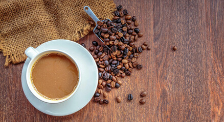 cup of coffee and coffee beans in a sack on  Brown background, top view