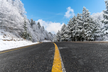 Mountain road landscape covered in snow in winter - 568792972