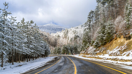Mountain road landscape covered in snow in winter - 568793178