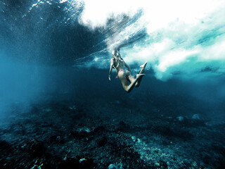 woman underwater playing with waves